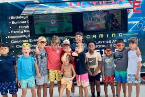 Children celebrating in front of the Ultimate Mobile Gaming game truck at a birthday party