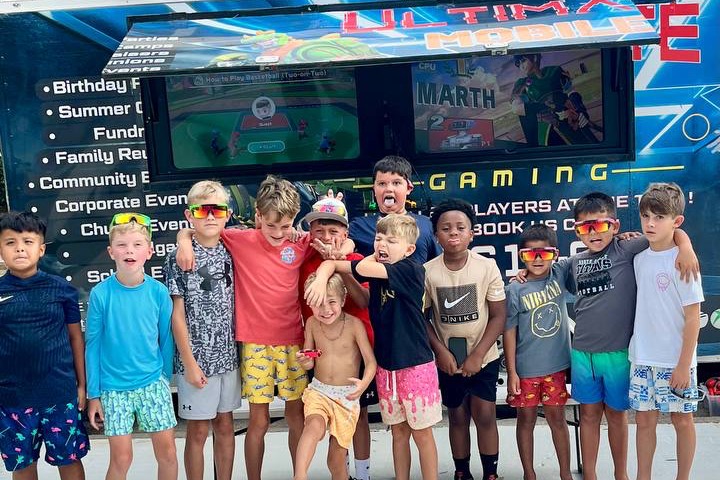 Children celebrating in front of the Ultimate Mobile Gaming game truck at a birthday party