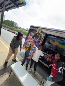 Children celebrating beside the Ultimate Mobile Gaming truck during a group event
