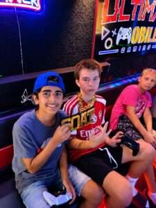 Teen guests holding game controllers inside the Ultimate Mobile Gaming game truck